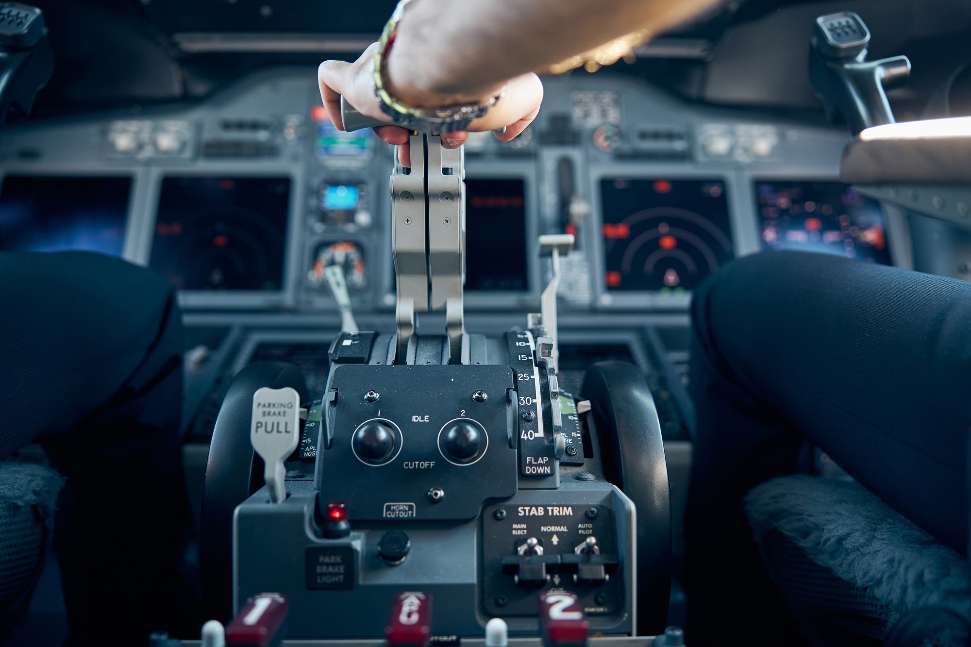 Captain hand accelerating on the throttle in commercial airplane